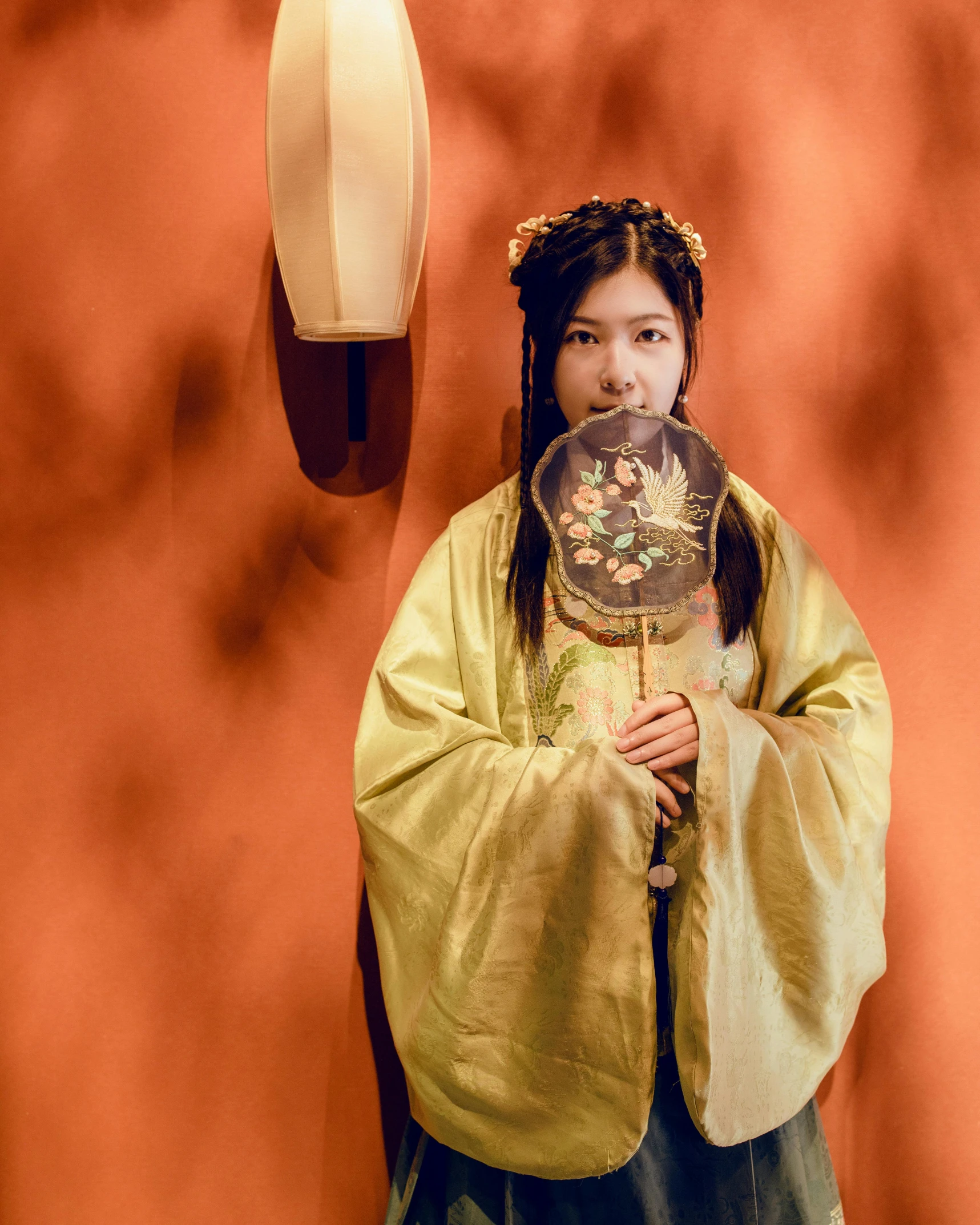 an oriental girl dressed in traditional clothing poses for a po