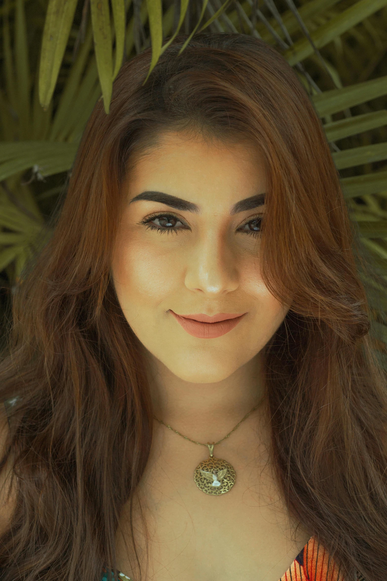 a woman posing for a pograph wearing a colorful shirt