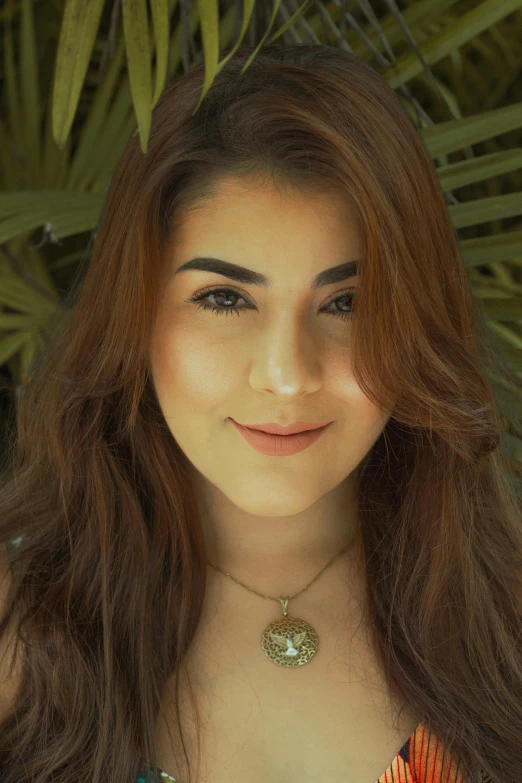 a woman posing for a pograph wearing a colorful shirt