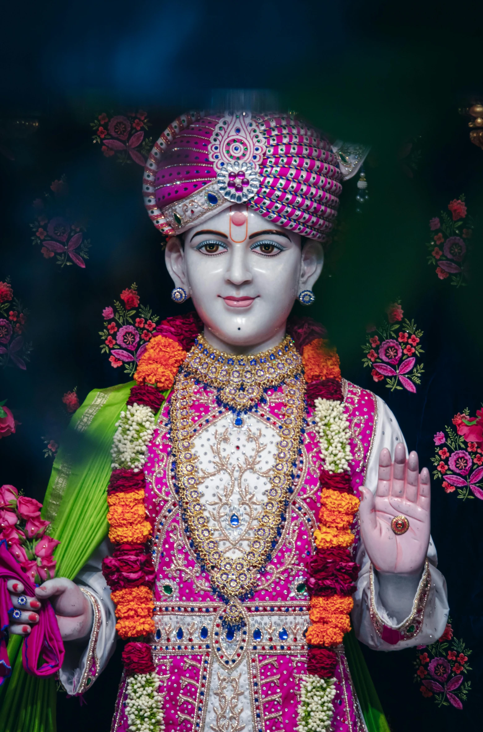 an indian god dressed in traditional colors making a sign