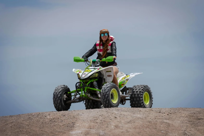 woman sitting on a quad motorbike riding across sand