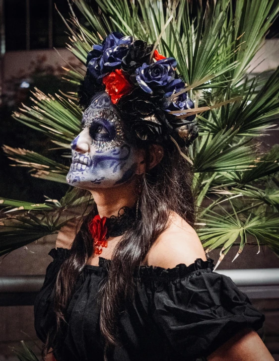 a woman with blue face paint and a red flower head piece