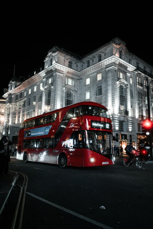 a double decker bus is parked outside a tall building