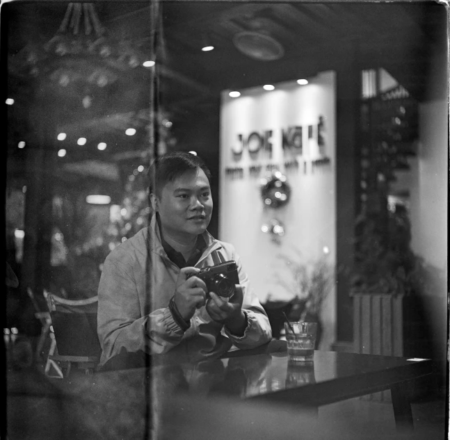 a man sits at a table looking at his phone