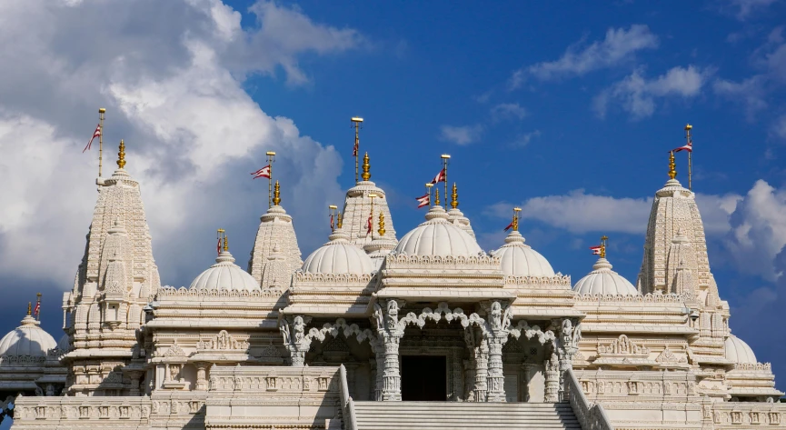 a white and gold temple with flags in the windows