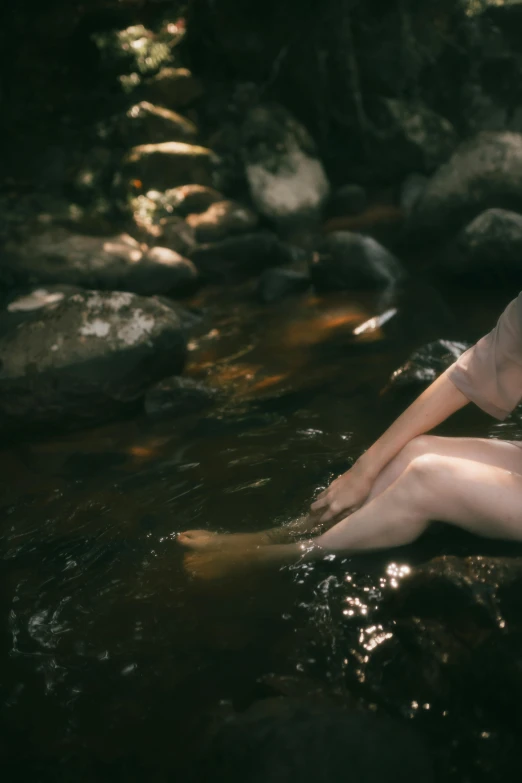 a person with her hand in their back is on the rocks