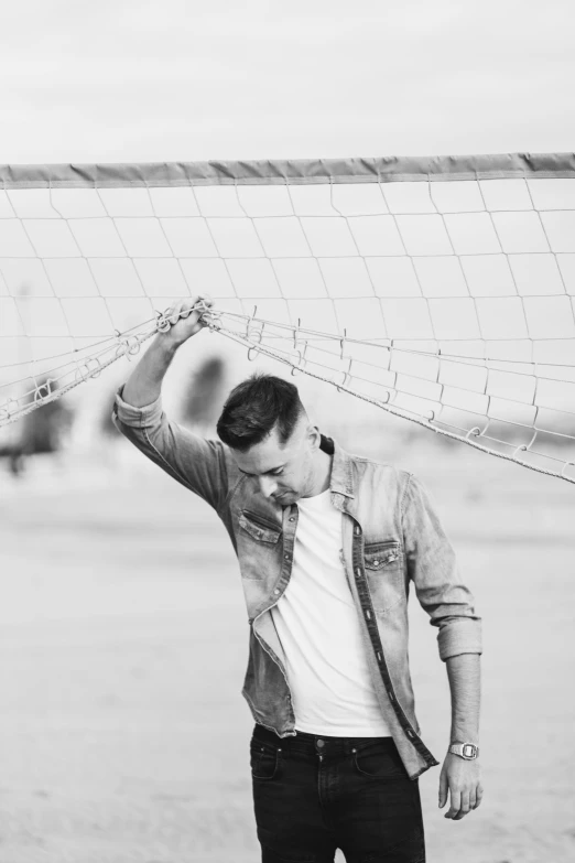 a young man is holding onto the volleyball net