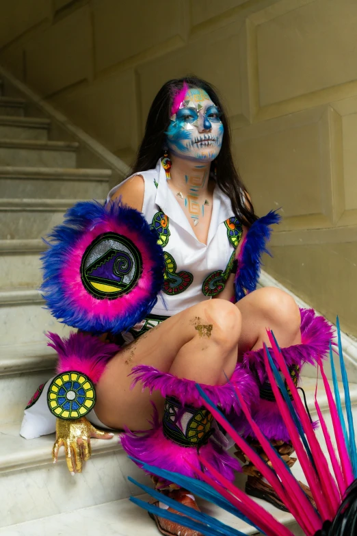 a young lady with makeup and costume on sits on stairs