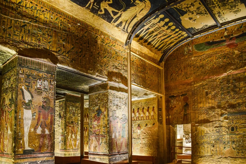 a corridor with wall paintings and pillars in it