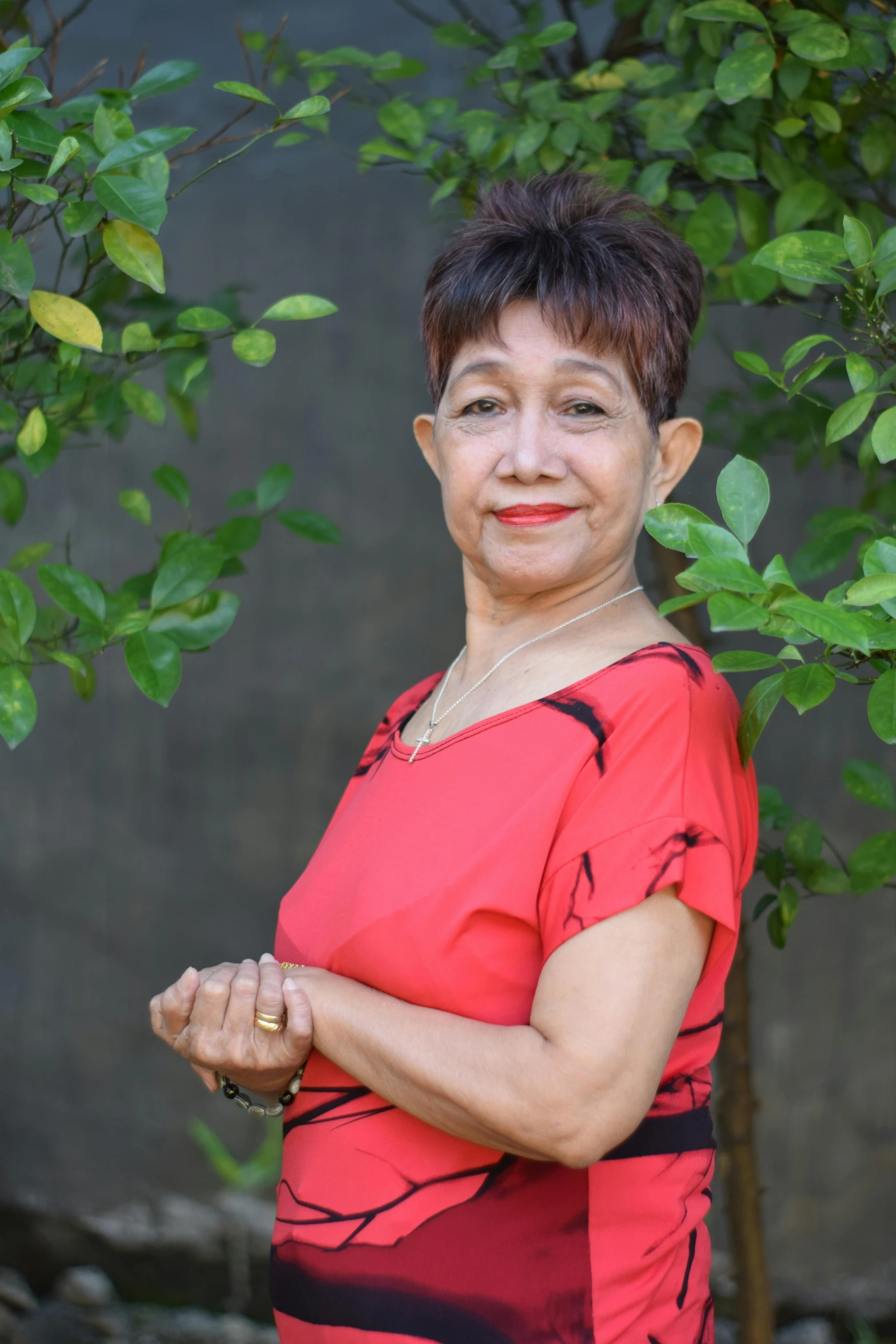 a smiling woman with dark hair and red shirt