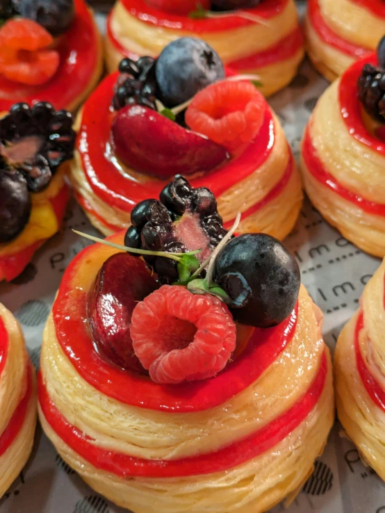 some pastries covered with fruits and sauces