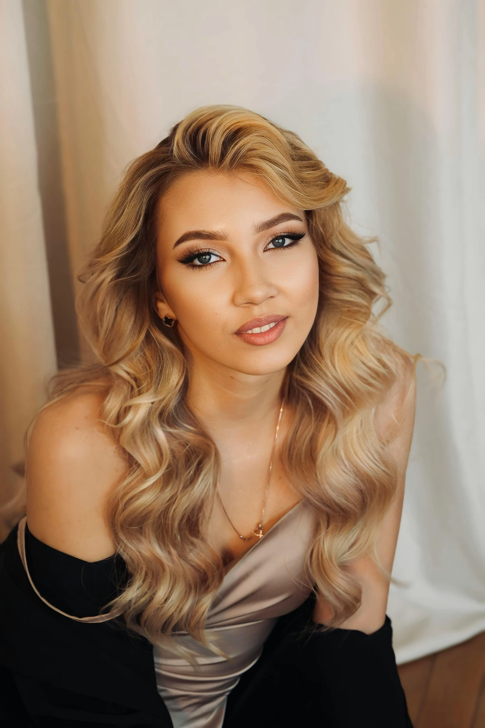 a woman with blonde hair wearing black, posing for the camera