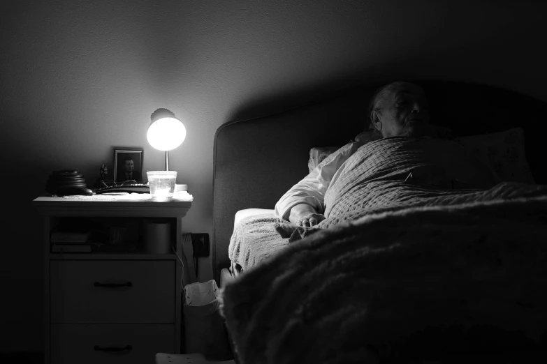 an elderly man is sleeping in his bed