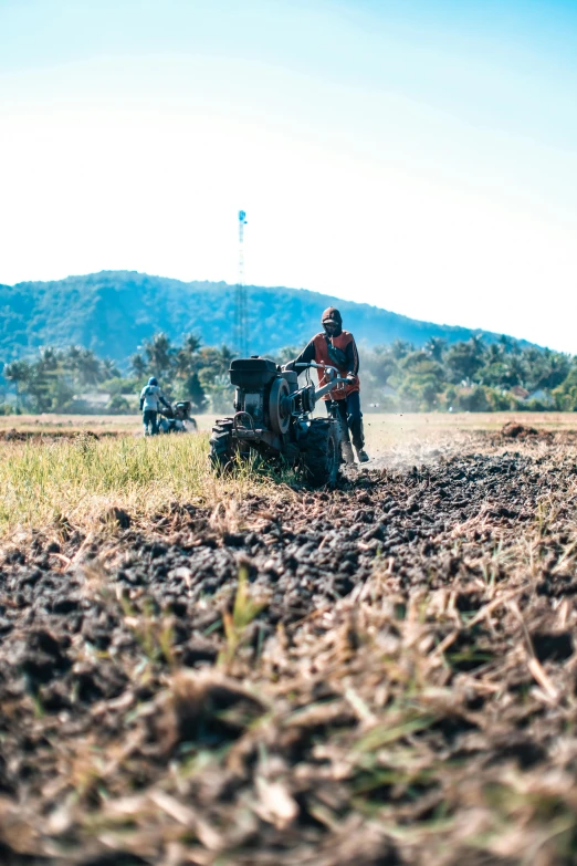 a person is working in a field on a tractor