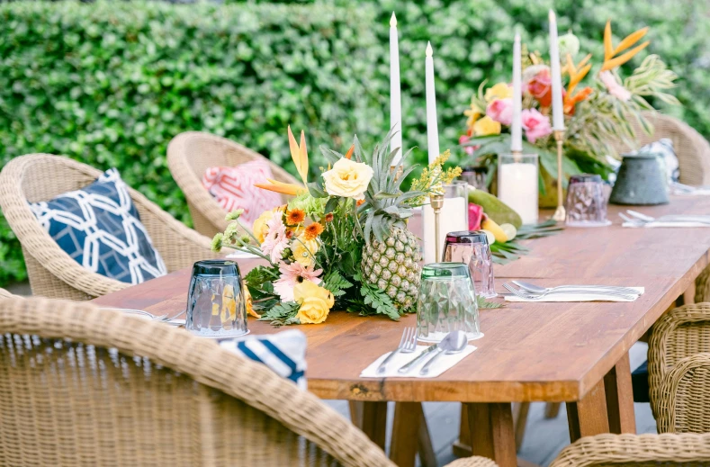 table with yellow and pink flowers with tall candles