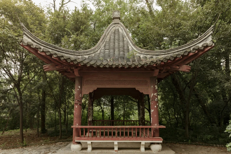 there is an asian style gazebo in the woods