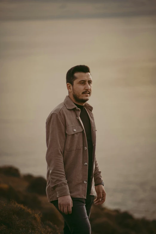 a man standing on a cliff overlooking the ocean