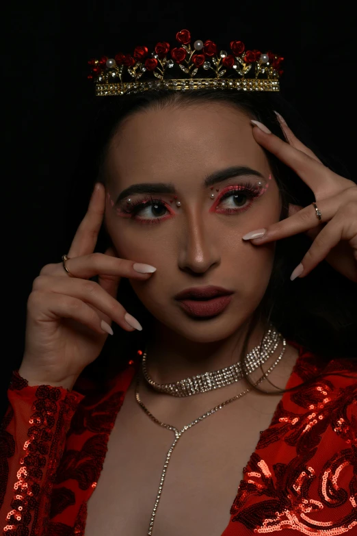 a woman with long nails and a crown on her head