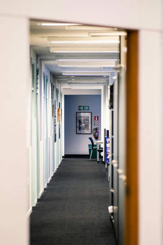 the view of a long hallway with posters on the wall