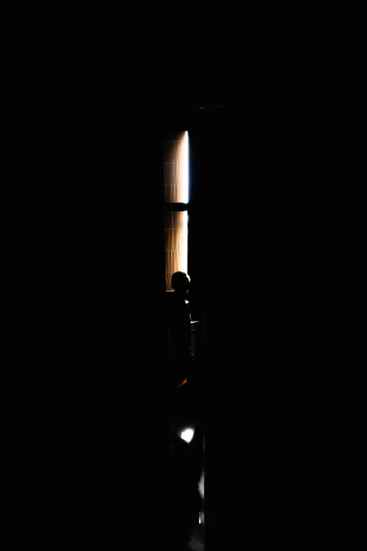 a po of someone in the dark, looking at soing through a window