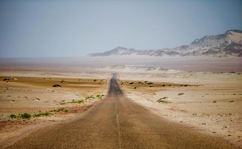 a lone dirt road going through the desert