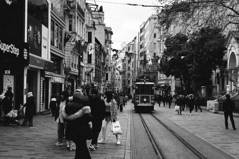 a street filled with people and a trolley train