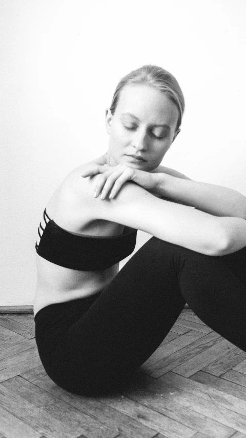 a woman sitting on the floor with her arms crossed