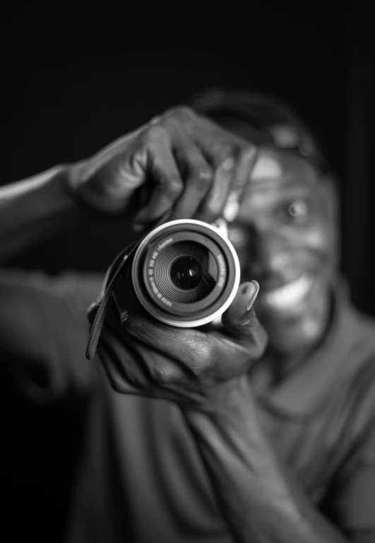 a man smiling and taking a picture with his camera