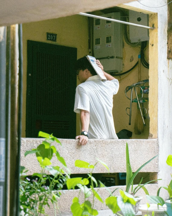 man standing in room with head turned backwards with a piece of paper on his face