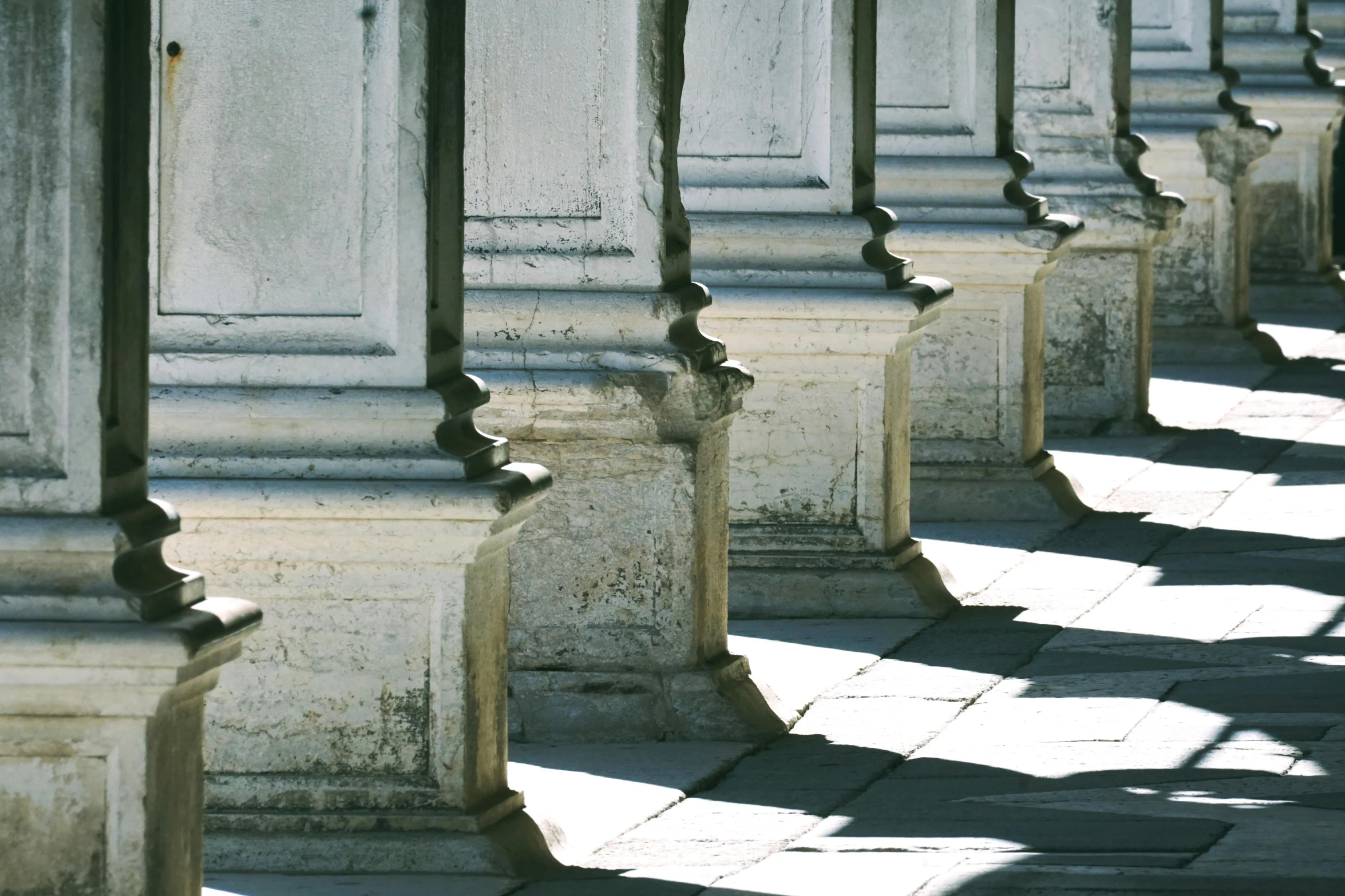 a sidewalk with concrete columns on either side