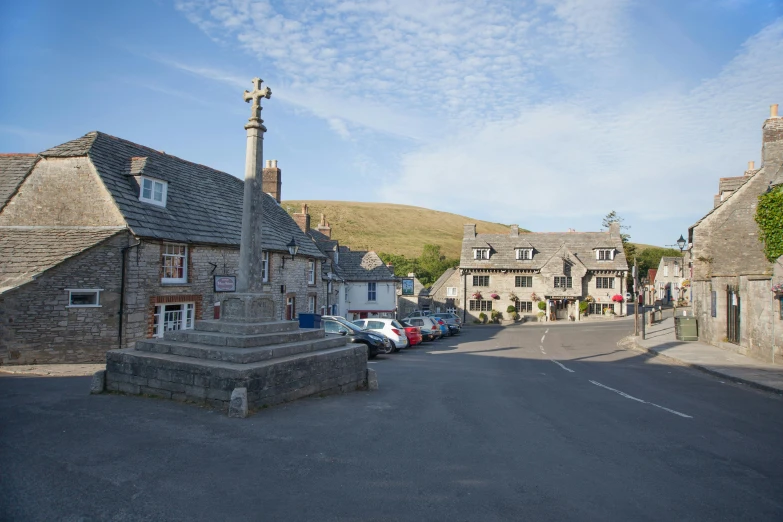 a street that has cars parked on the side and houses in the back