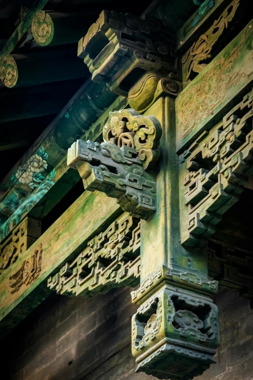 an ornate carving in green color on the side of a building