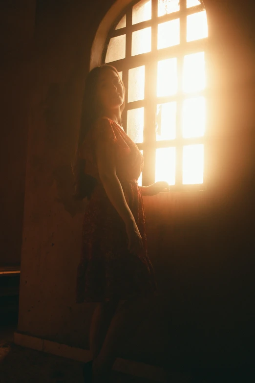 woman looking out window at sunset from bed