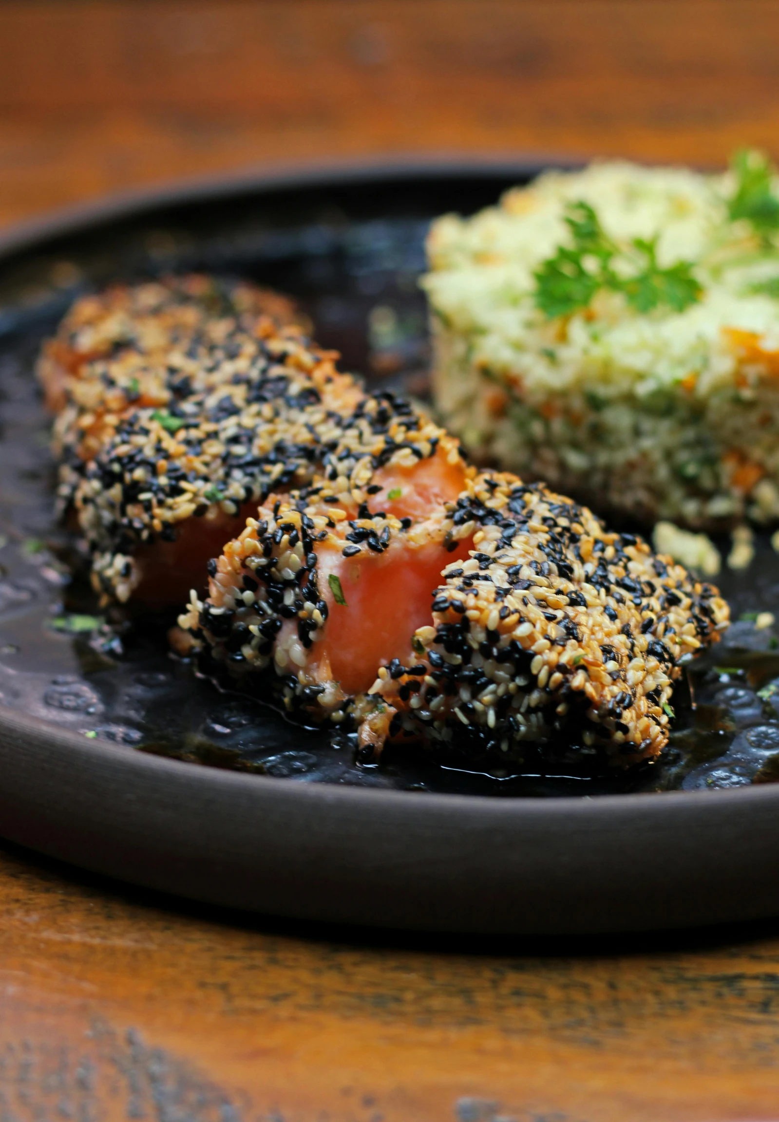 three pieces of food sitting on top of a black plate