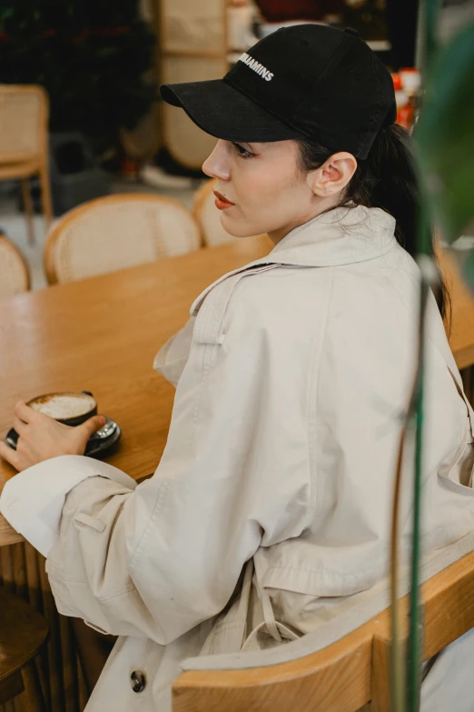 a woman sitting at a table in a white jacket