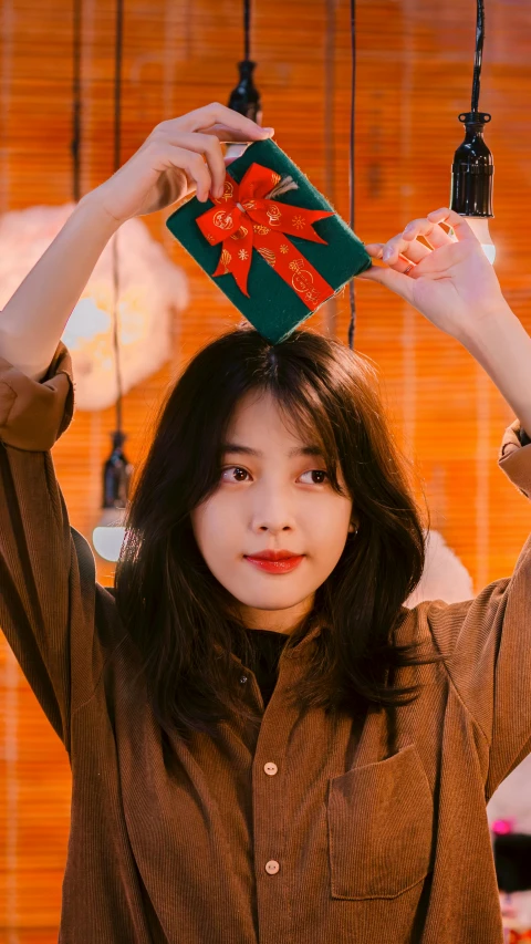 a girl holds a present as she stands near some other ornaments