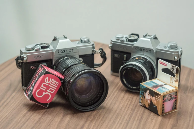 two old and vintage camera laying next to a sticker