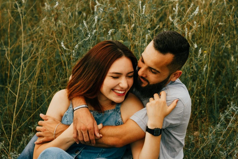 a couple cuddling in an open field