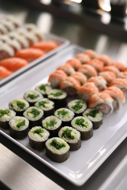 several plated sushi on a buffet table with other food items