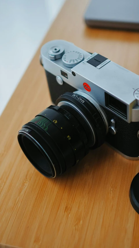 an old camera is resting on a wooden table