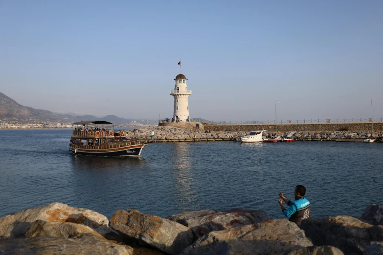 the light house is standing on a rock pier