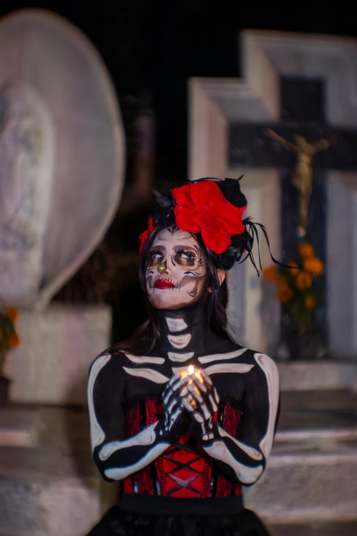 a person in skeleton make up holding a lit cigarette