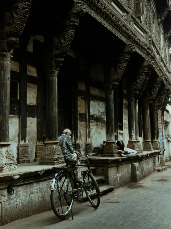 a woman standing with her bicycle parked next to a building