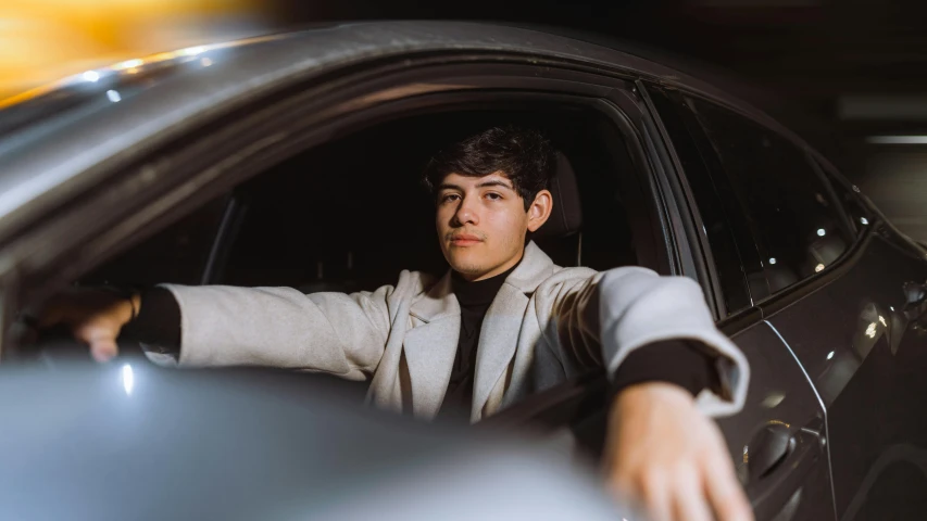 a man leans out the window of his car and points