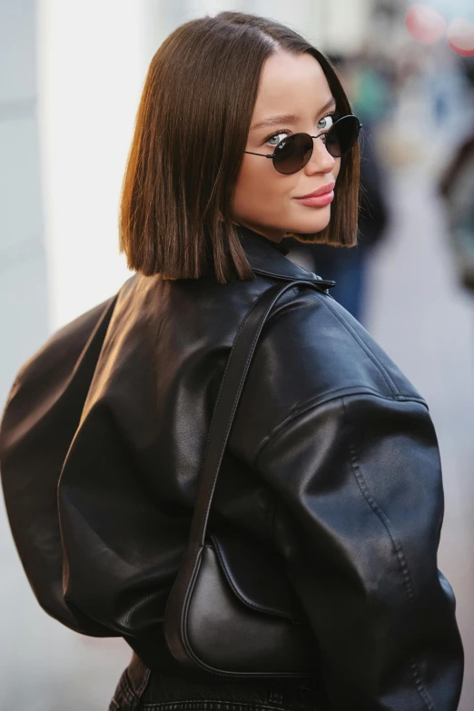 a woman wearing sunglasses and a black leather jacket