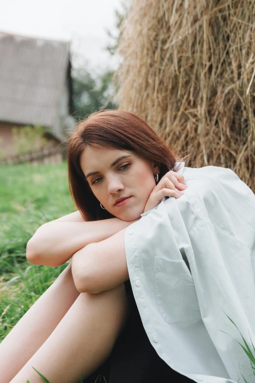 the woman poses for a po while posing by hay bales