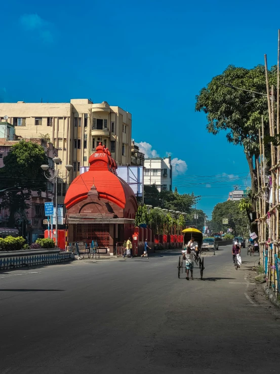 people walking and walking on the sidewalk next to a street with buildings and a dome