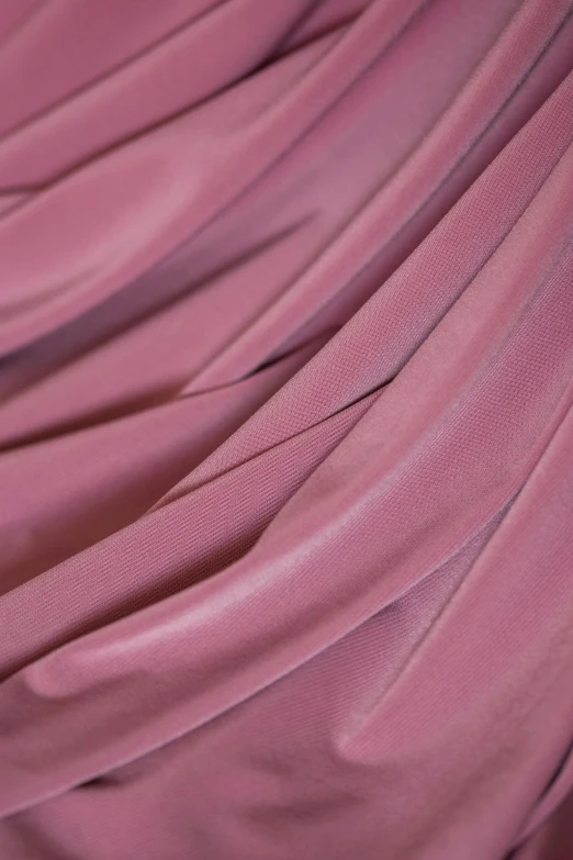 a piece of fabric in pink color that has thin strips