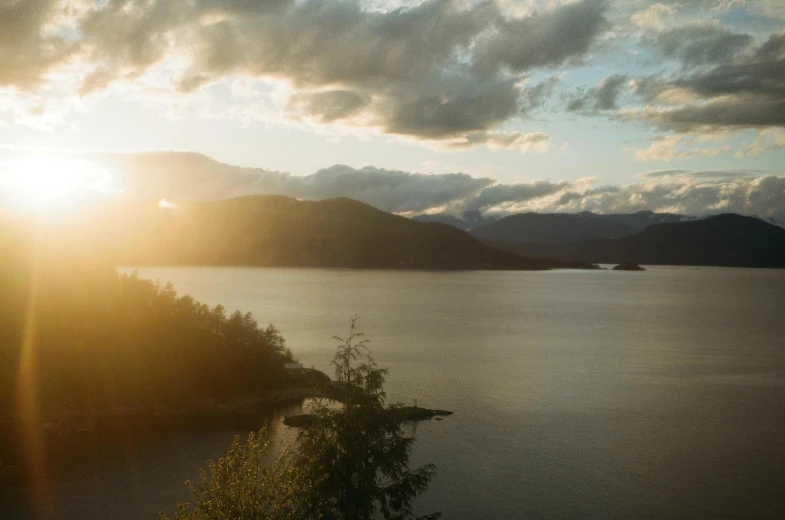 a lake that is next to some mountains with clouds