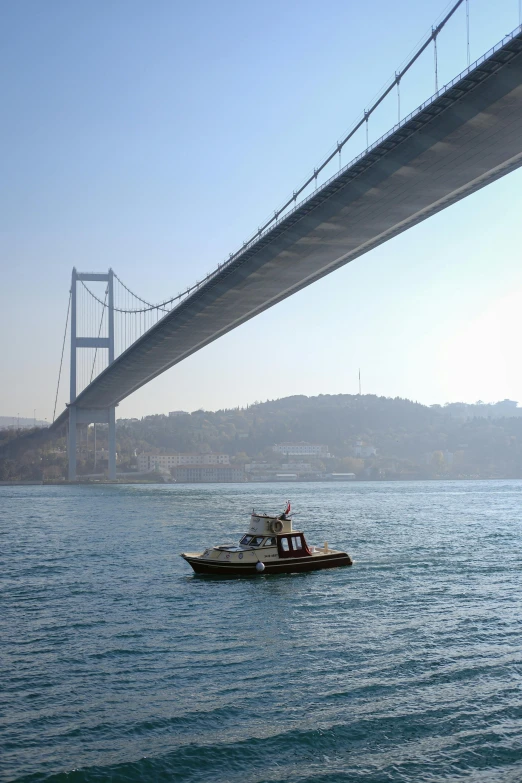 a small boat floats down the water under the bridge